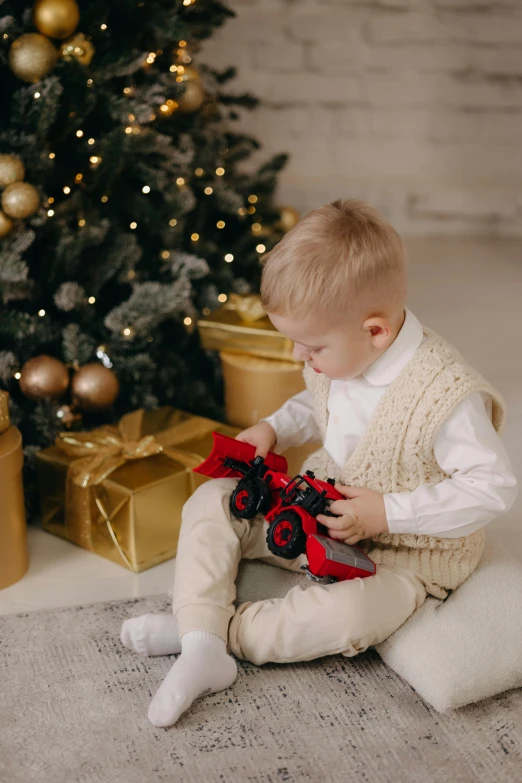 a little boy sitting on the floor playing with toys