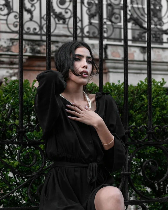 a lady is standing in front of a gate