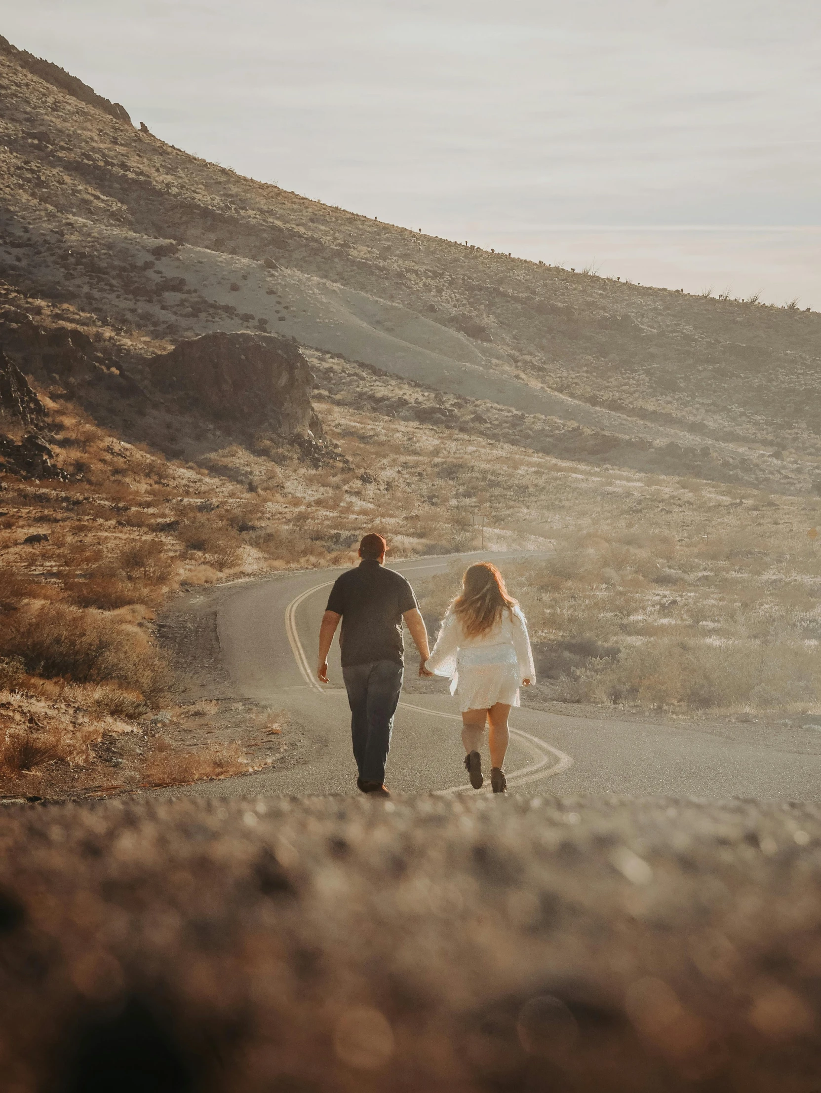 two people are walking in the middle of the road