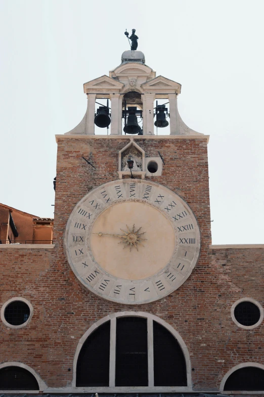 an old fashioned clock tower with bells at the top