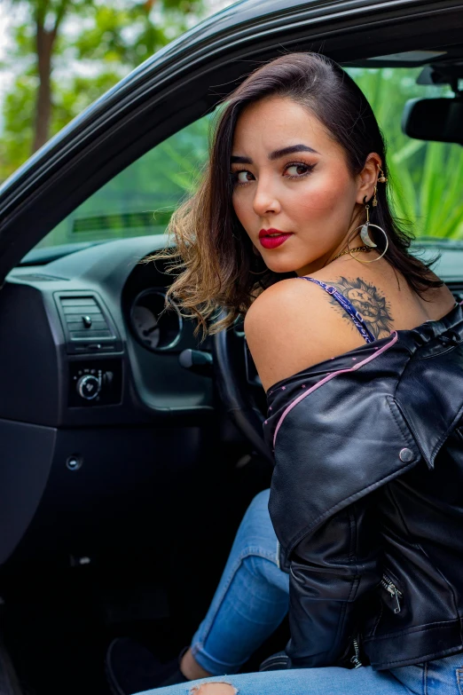 a woman sitting inside of a black car