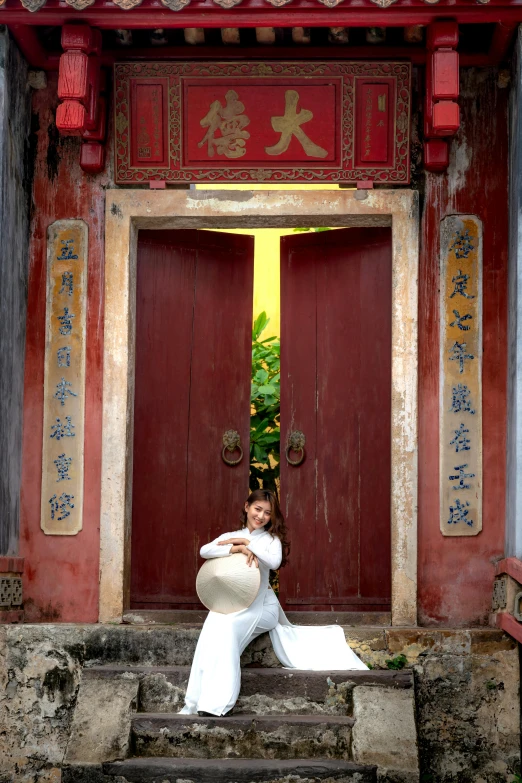 a beautiful woman posing on steps next to a wooden door