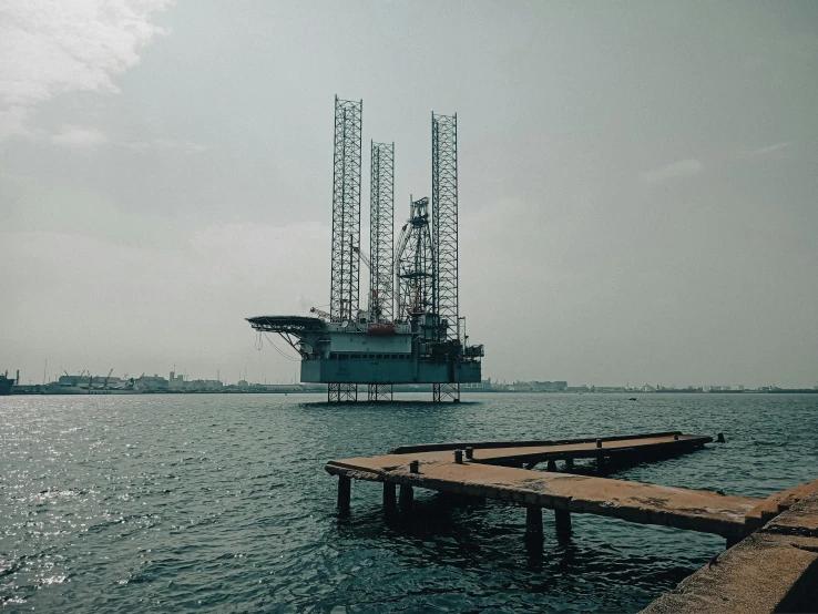 a barge sits at the dock next to an oil rig