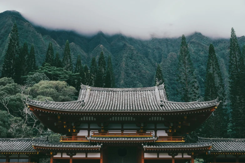 an asian style house with mountains and trees in the background