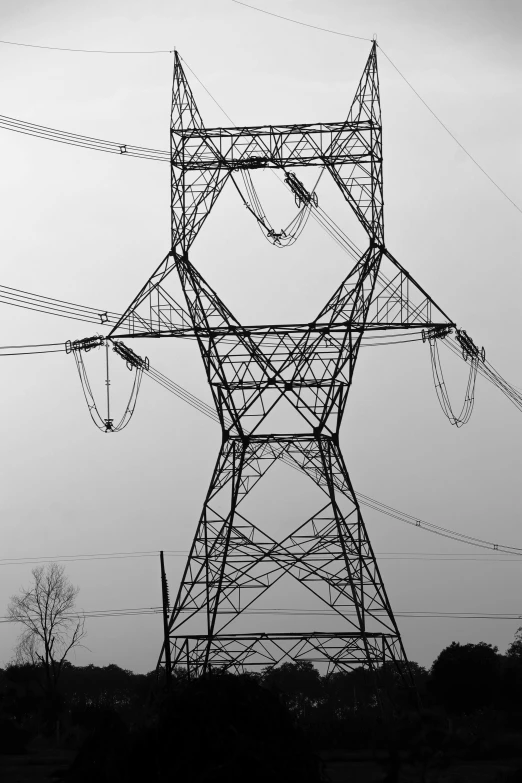 a large tower on a hill with some electrical wires above it