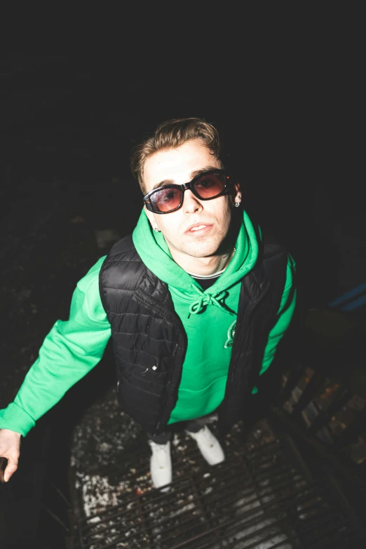 a man in a green jacket wearing sunglasses