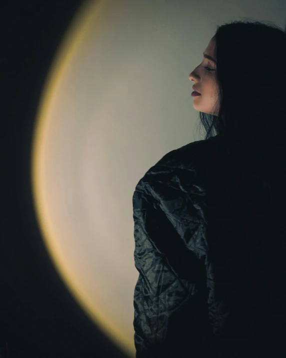 a woman standing in front of an illuminated circle
