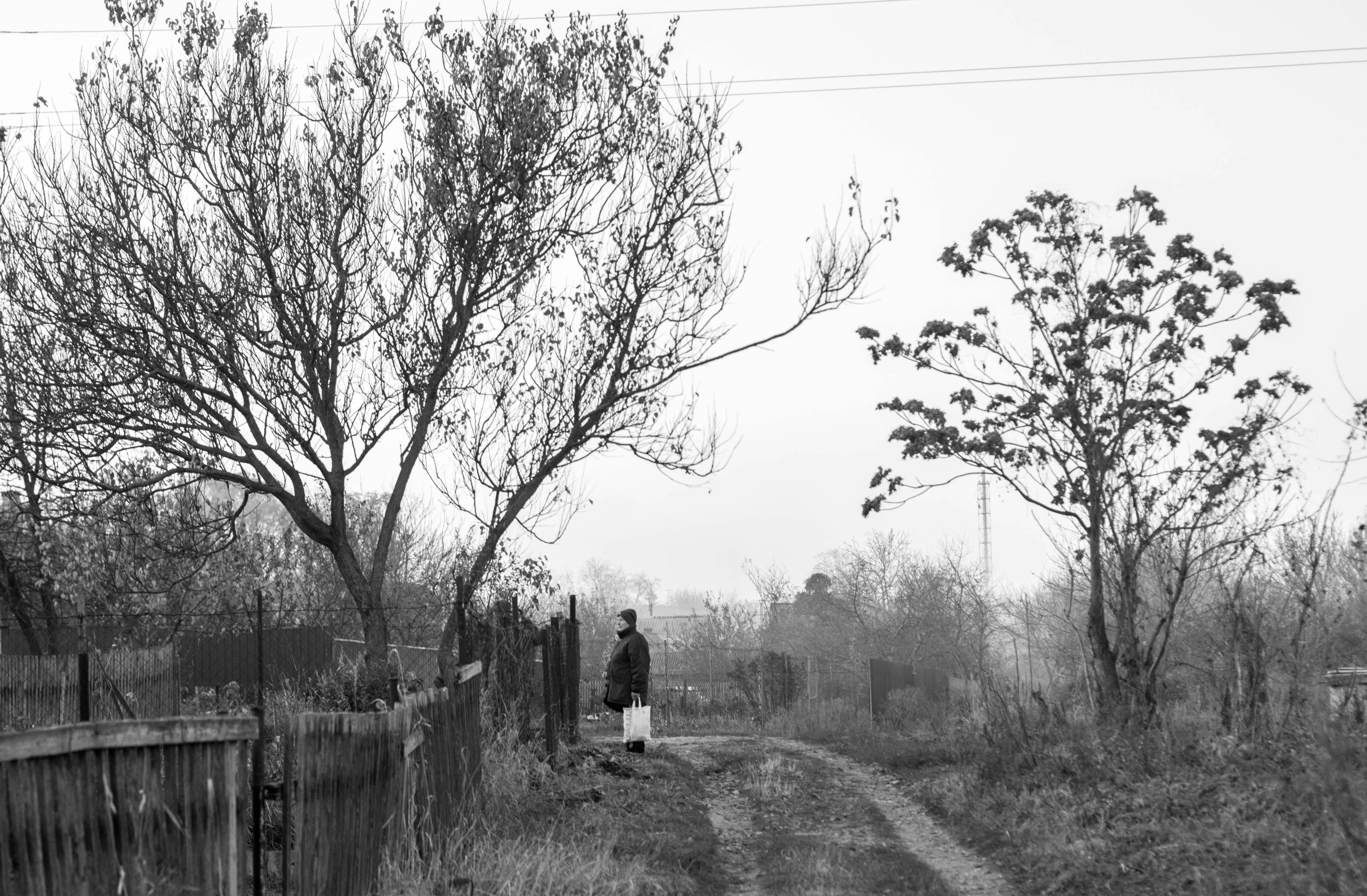 a black and white po of two people walking down the road