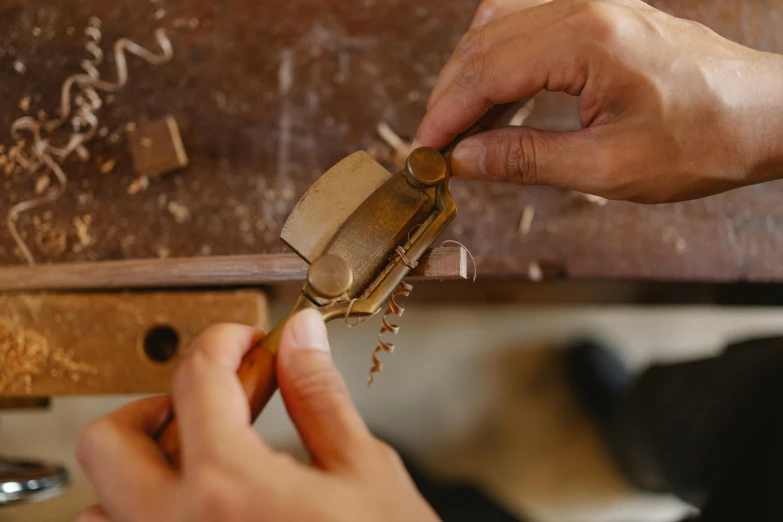 someone using a metal tool on a piece of wood