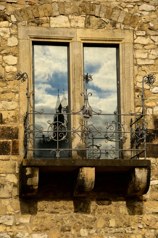 a window with ornate iron bars and gargoyles