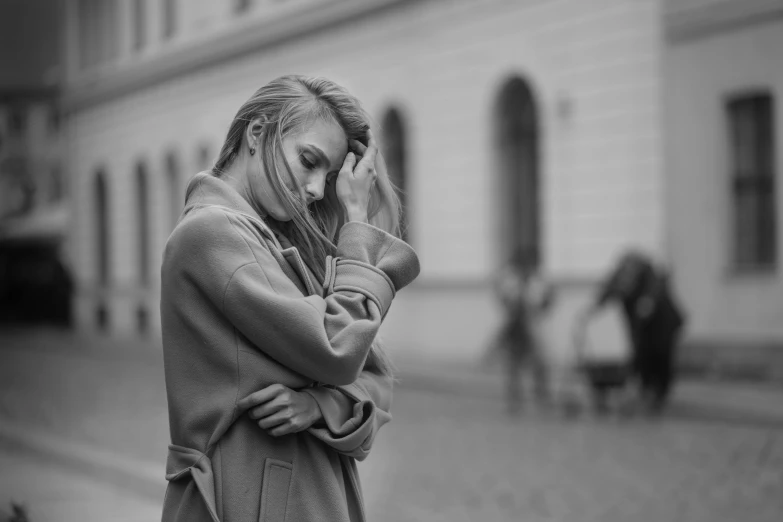 there is a woman standing on the street on her cell phone