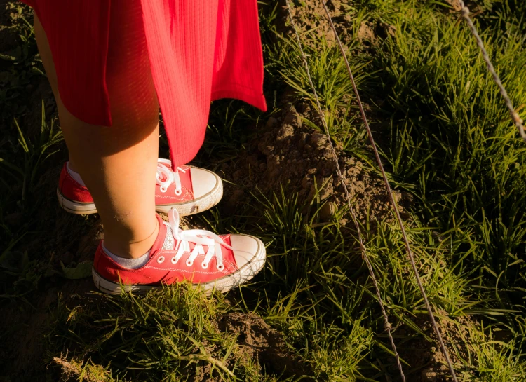 a red shirt on someone in red sneakers