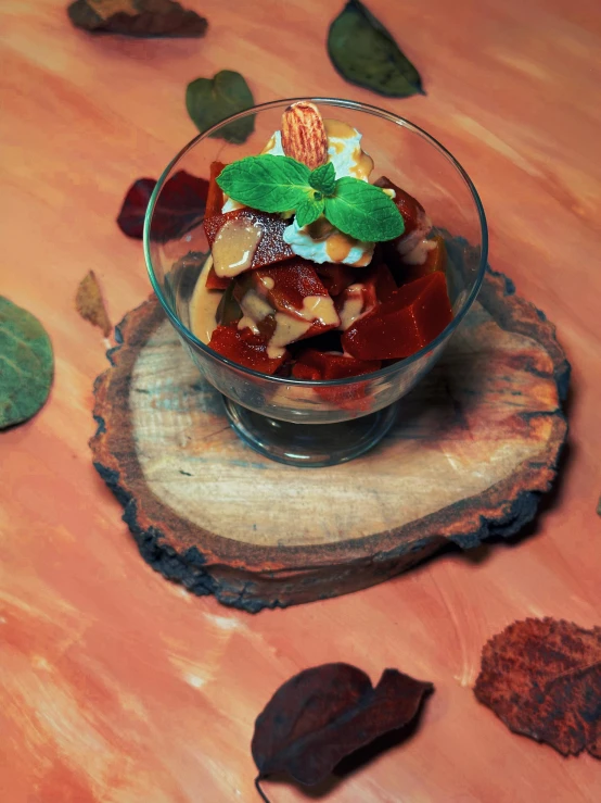 a glass bowl is on a tree stump with some decorations