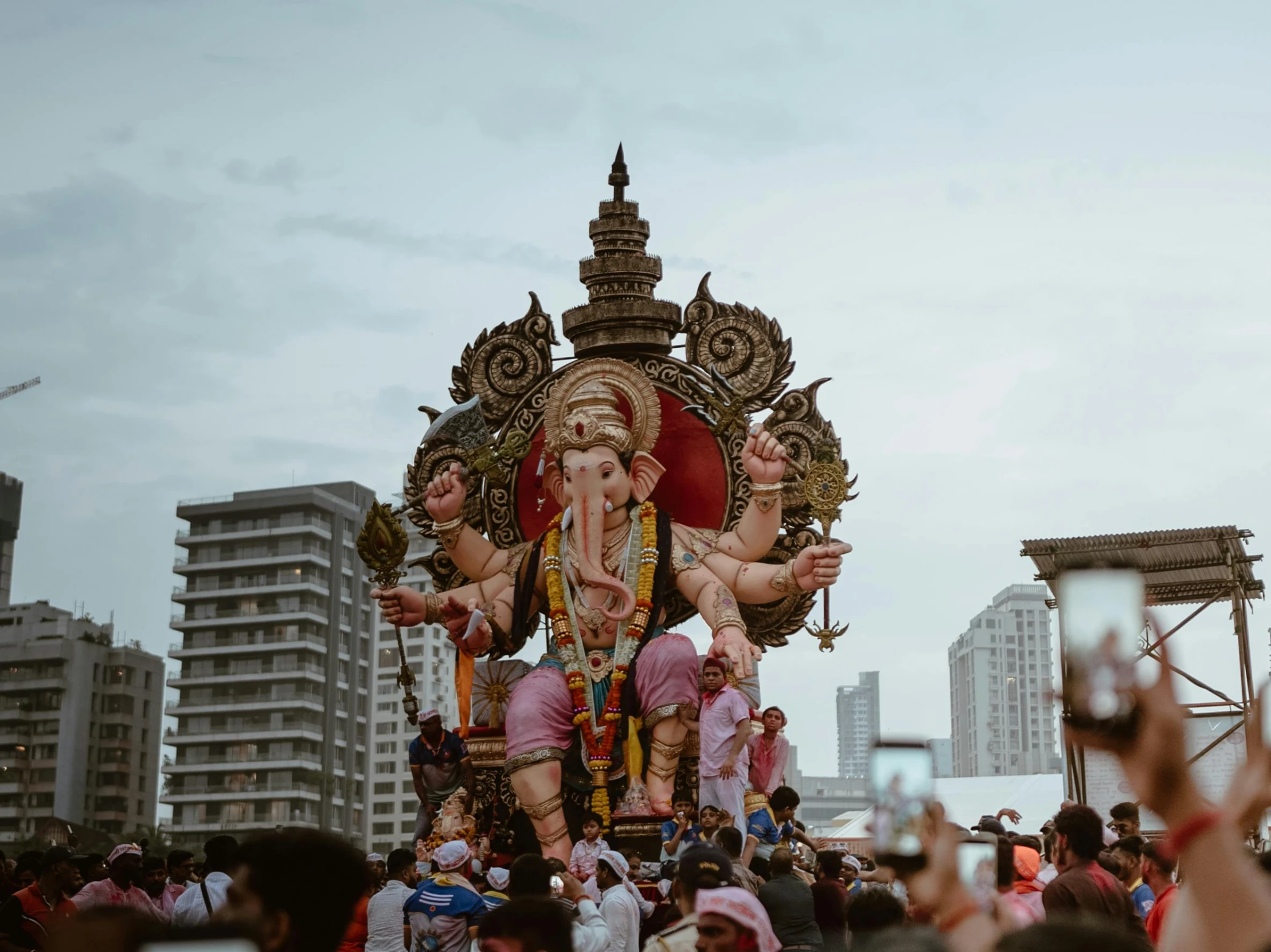 group of men taking pictures with their cell phone of large, elaborately decorated gan idol