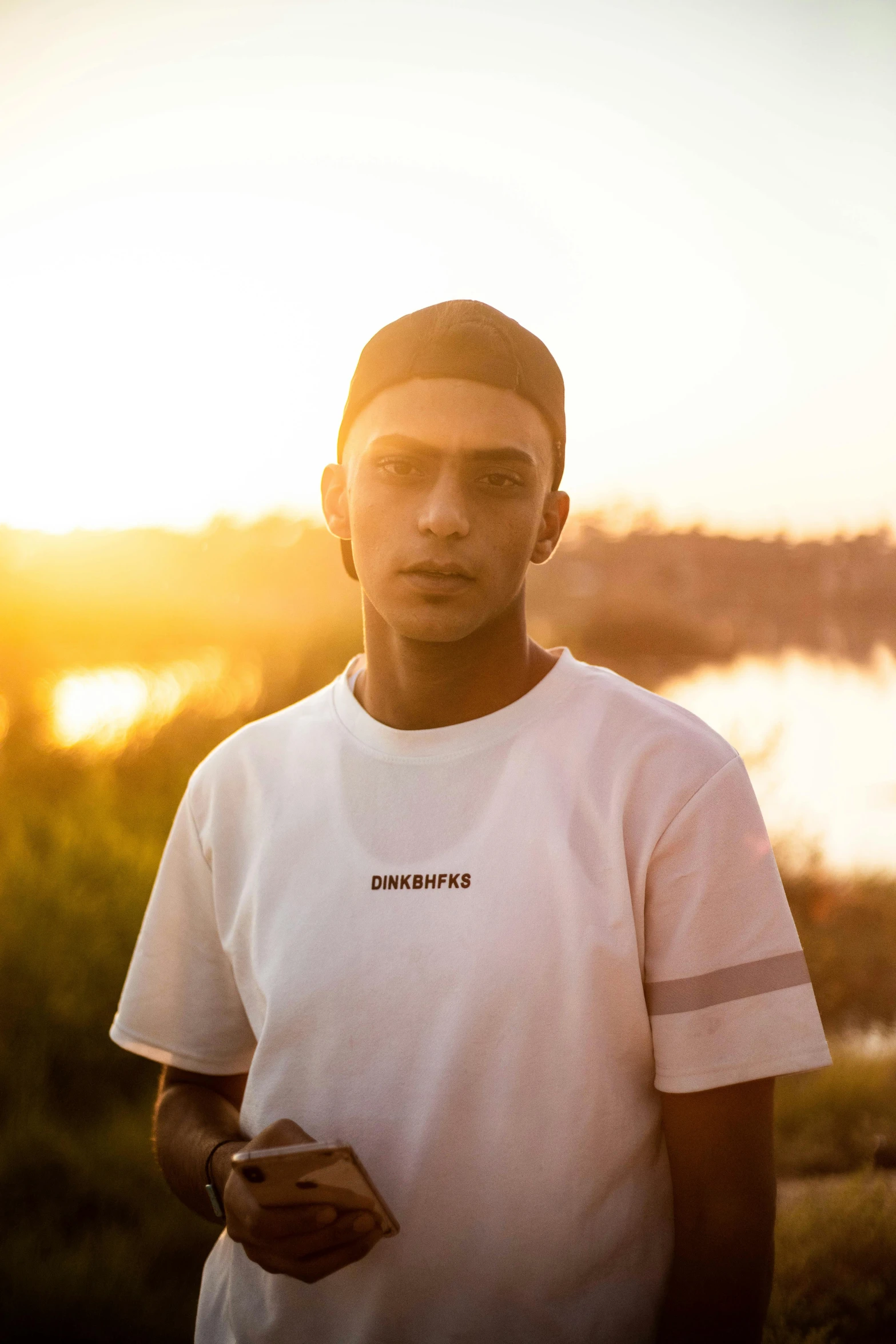 the man is posing for a po in front of water