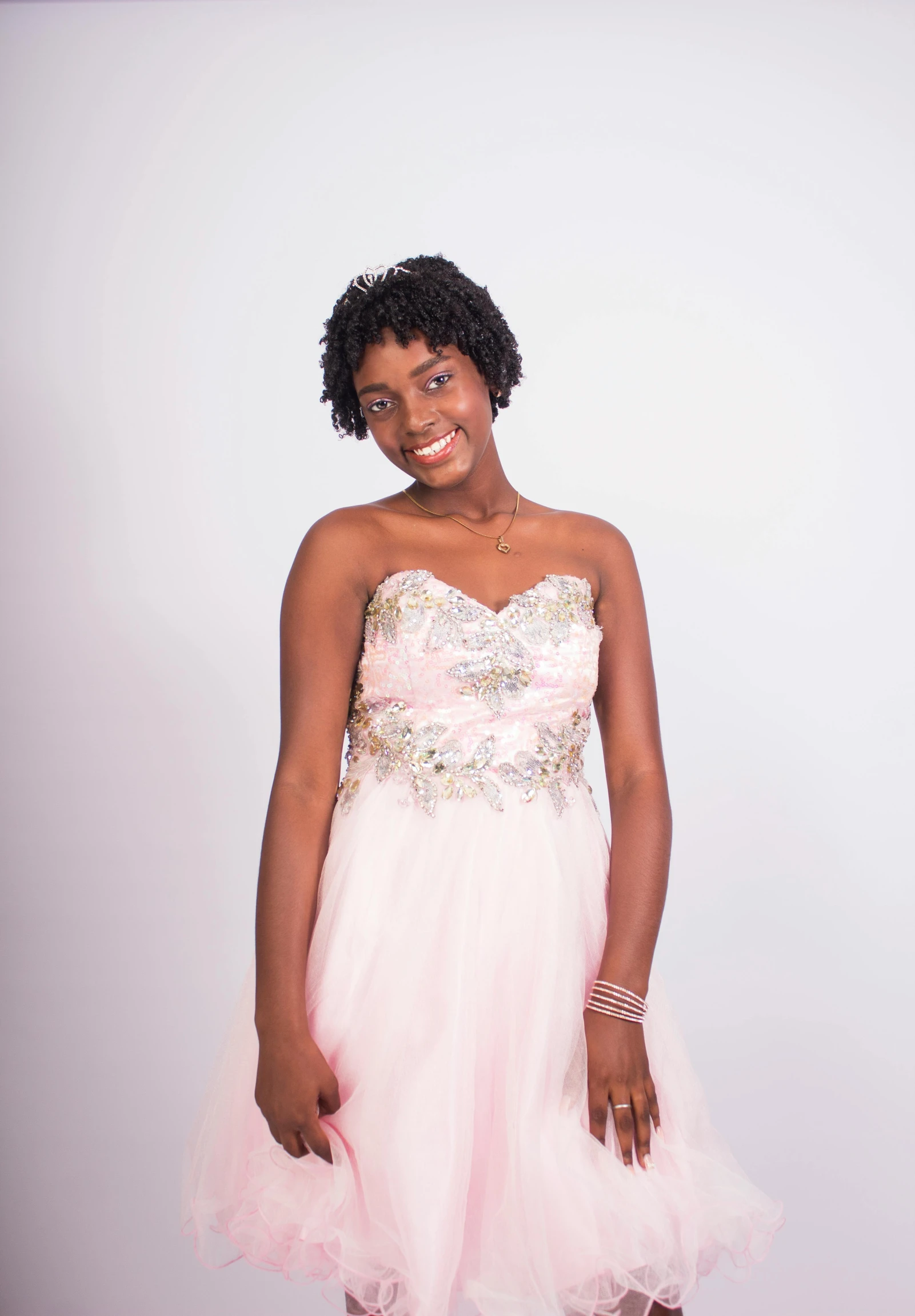 a young lady dressed in a pink dress posing