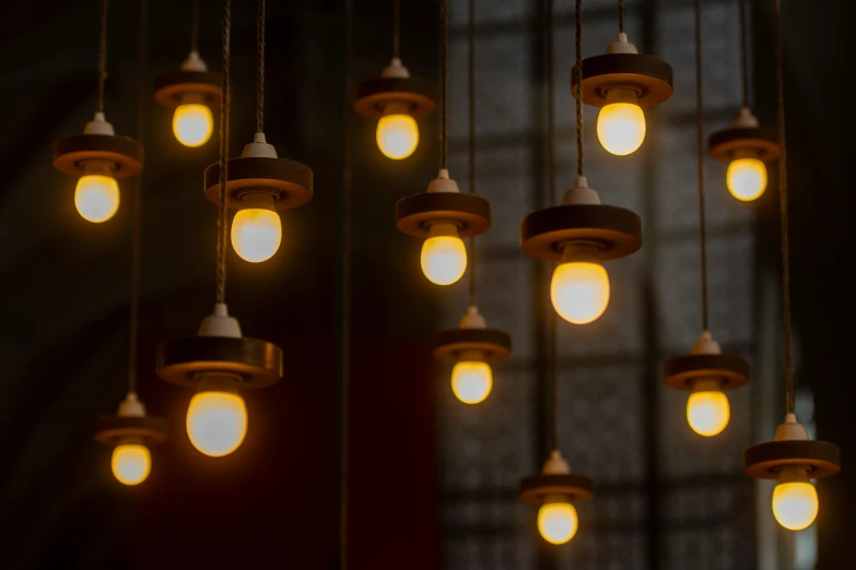 many light bulbs hang above the dark room