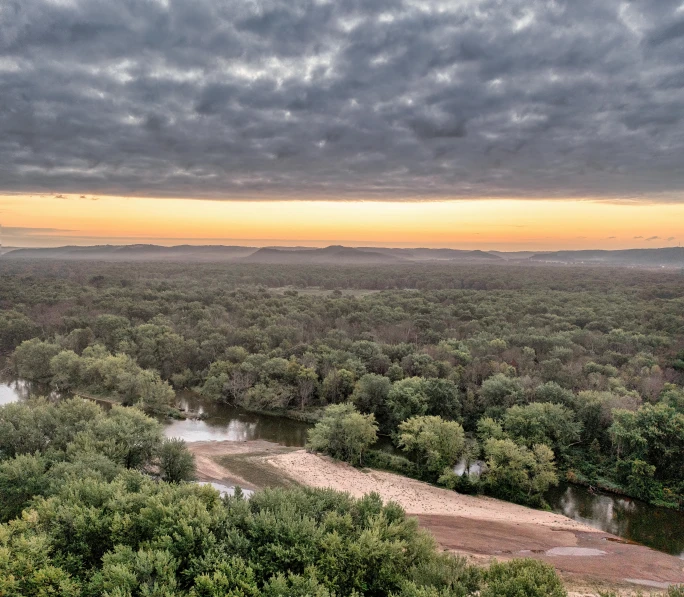 an aerial view of a small river and trees