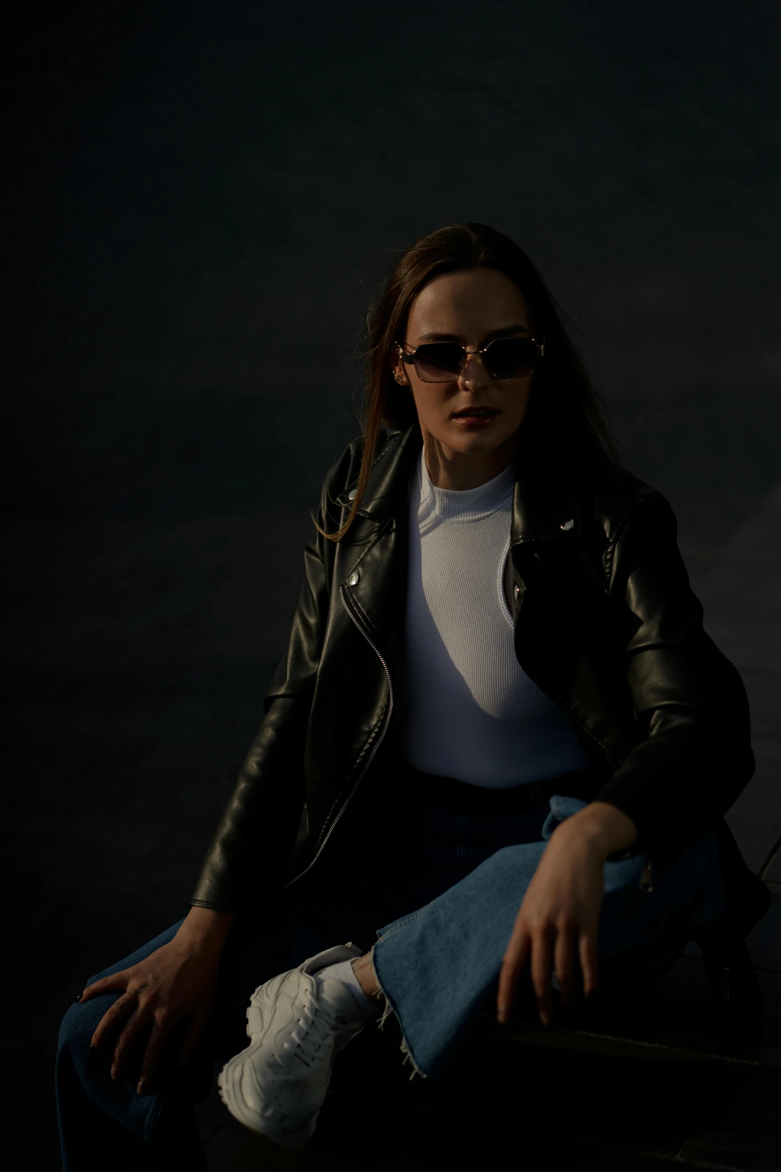 a young woman wearing sunglasses and a leather jacket