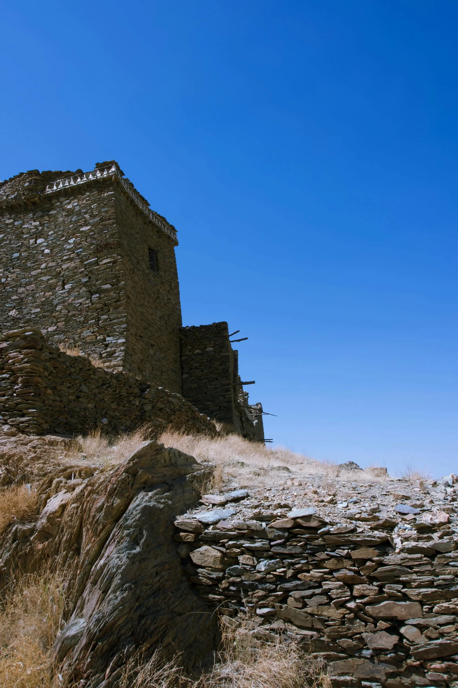 a stone castle that is next to a hill