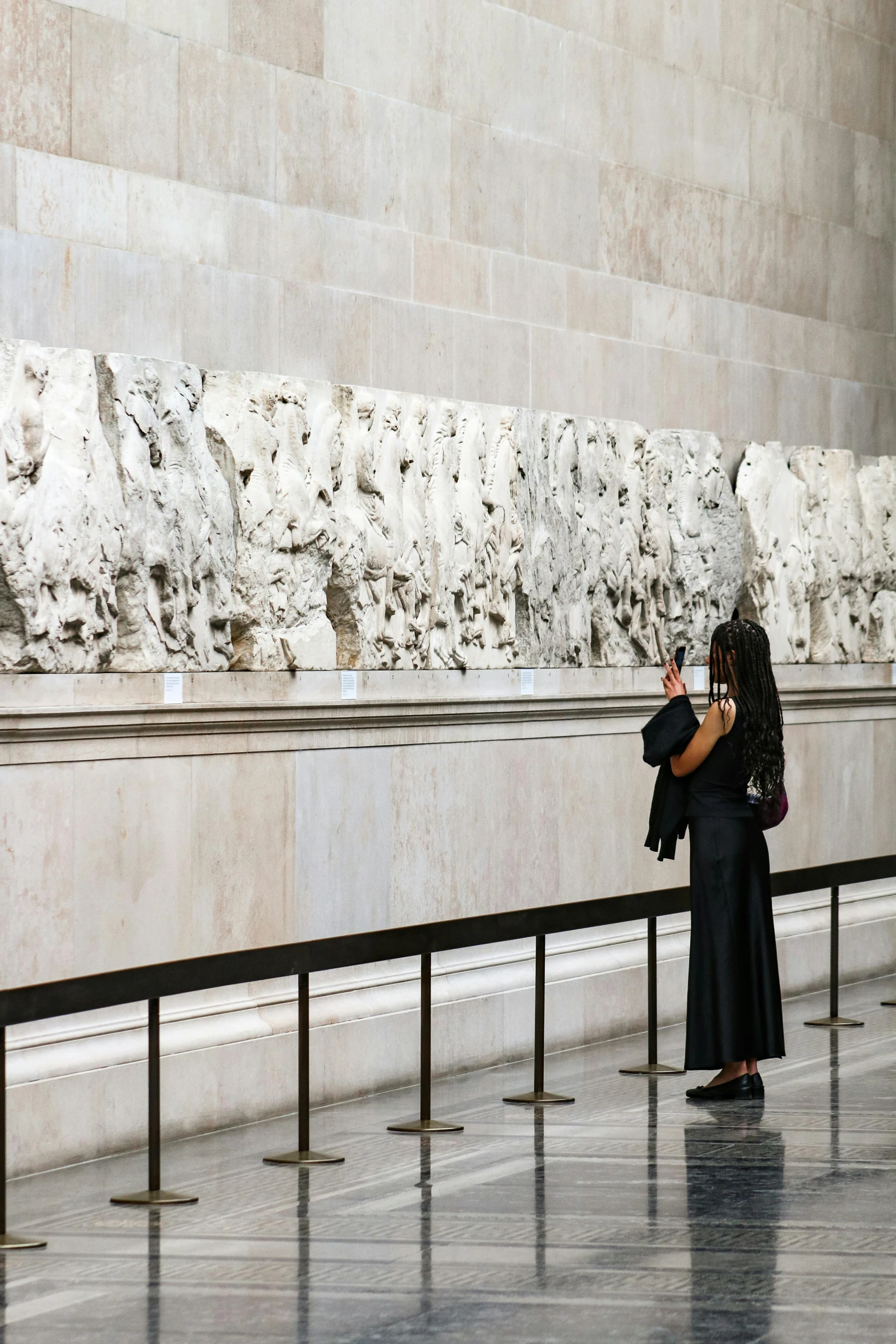 a woman standing by the wall taking a picture