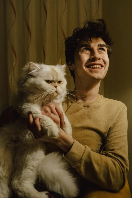 a man holds a cat while smiling