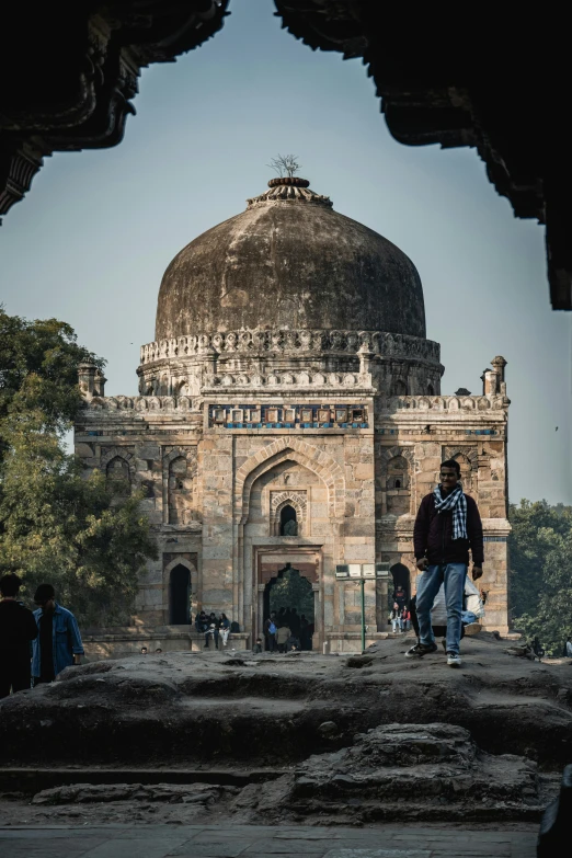 people in front of an ancient structure with a dome