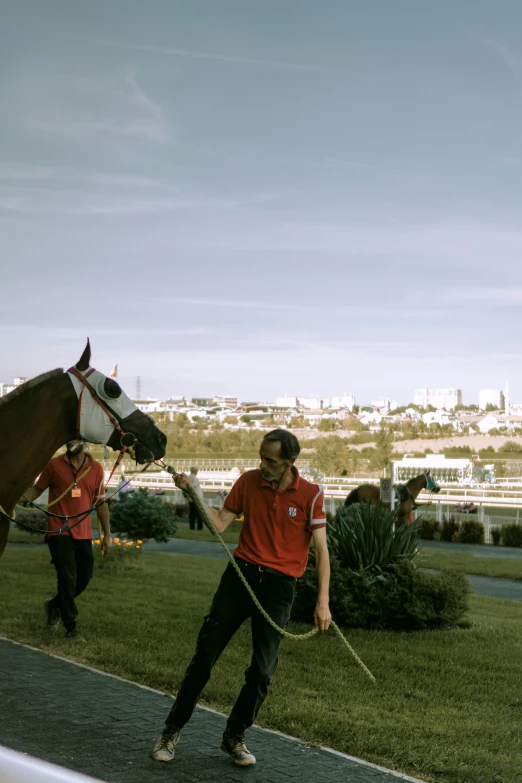 two women leading a horse and another holding it