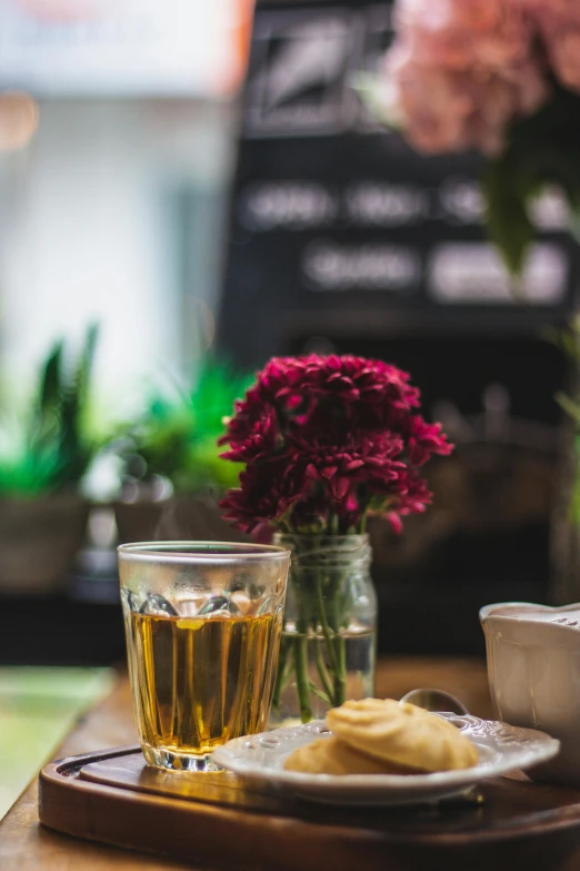 flowers and tea on a table with a glass