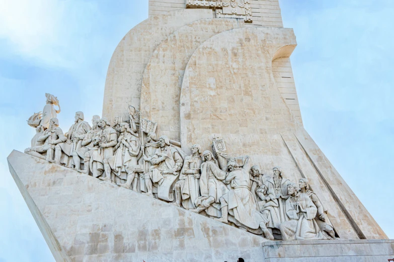 many statues of men sitting and standing on top of a stone structure