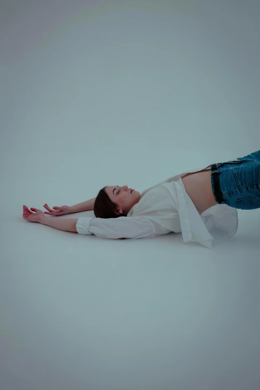 a woman is laying on the ground with her arms out