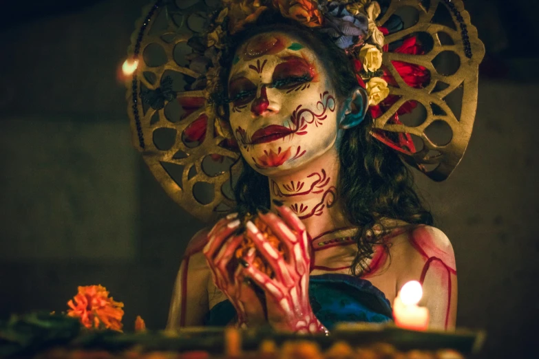 a woman with makeup and a mask on stands by a plate with flowers