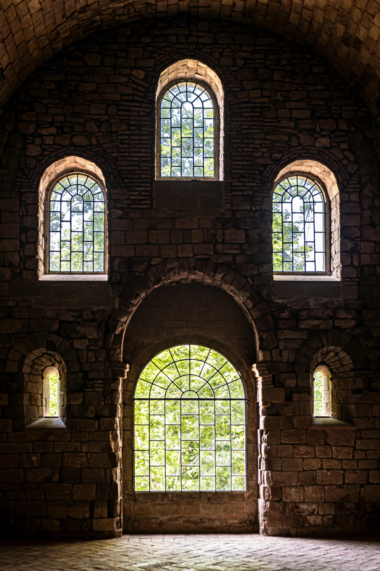 a brick arch with two arched glass windows