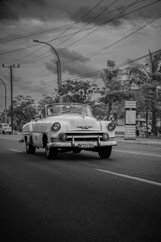 a white and black po of a classic car on a city street