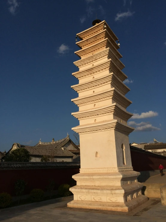 a tall white sculpture in front of a blue sky