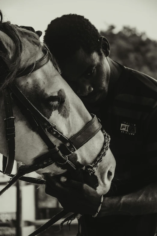 a man is petting a horse with a muzzle