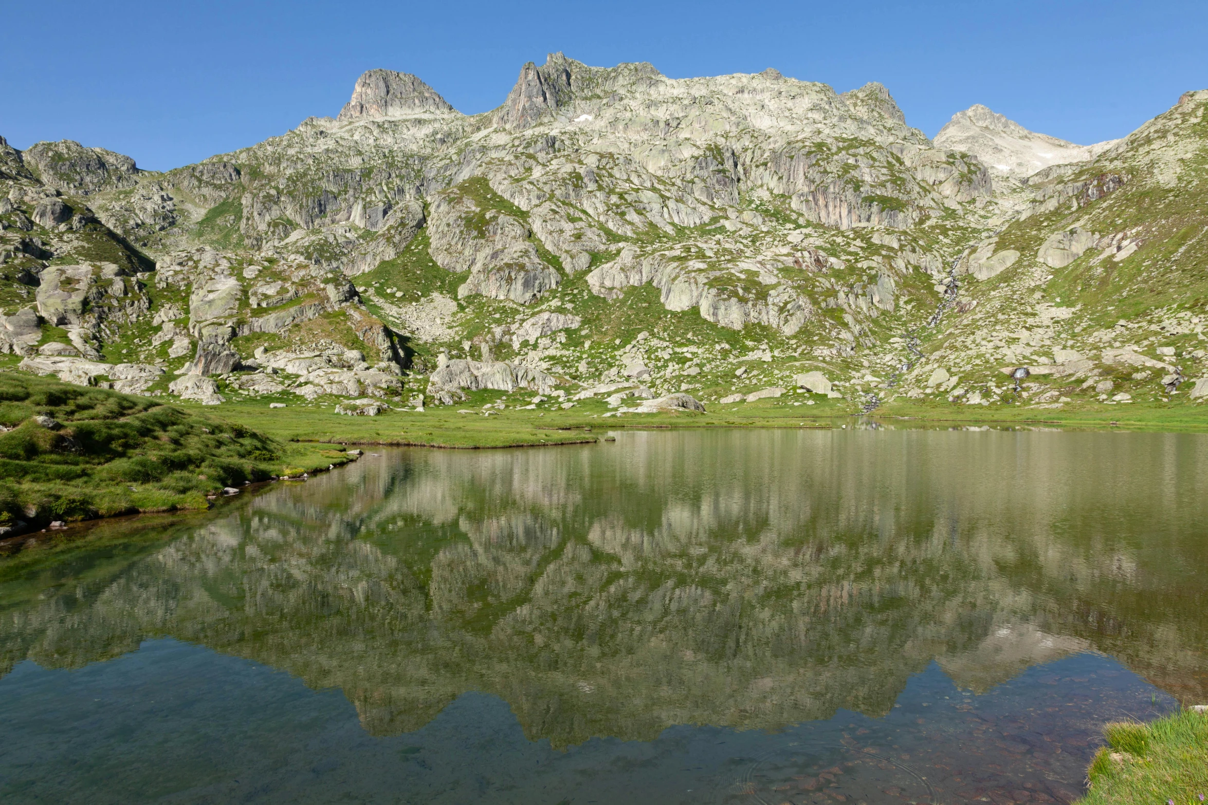 a lake in the mountains with people walking in it