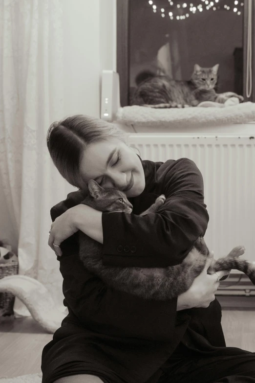 a woman holding a cat in her arms in front of a mirror