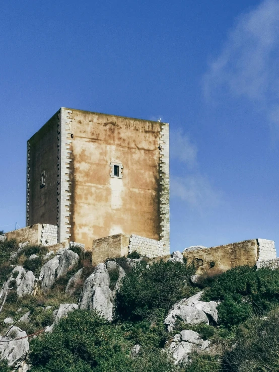 an old building stands on top of a rocky hill