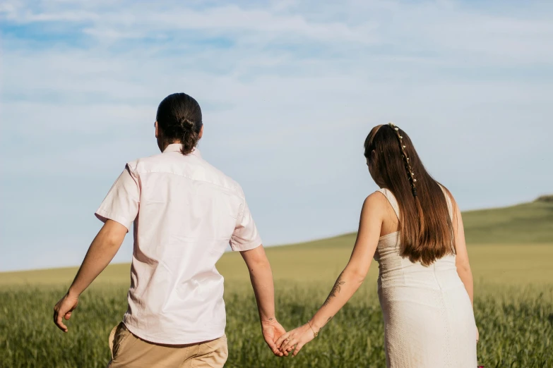 a man and woman holding hands while looking at the sky