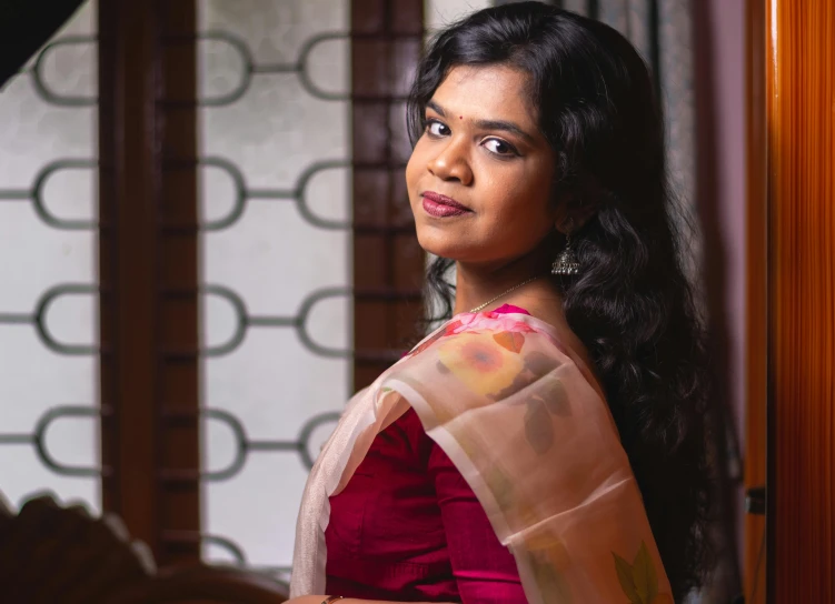 a woman in a red and pink sari posing