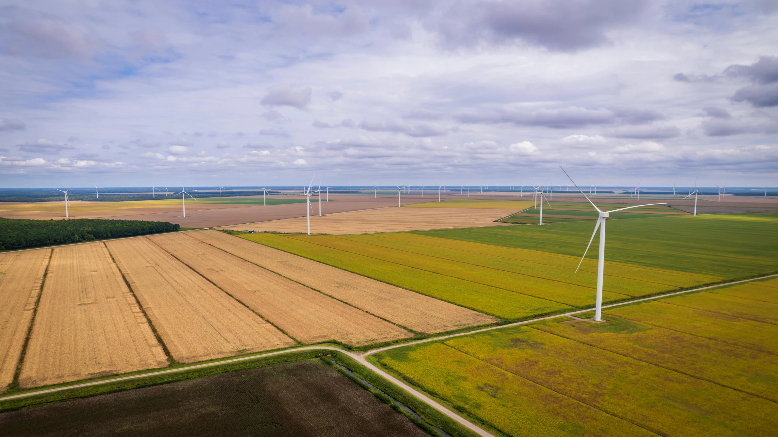 wind turbines next to a farm landscape