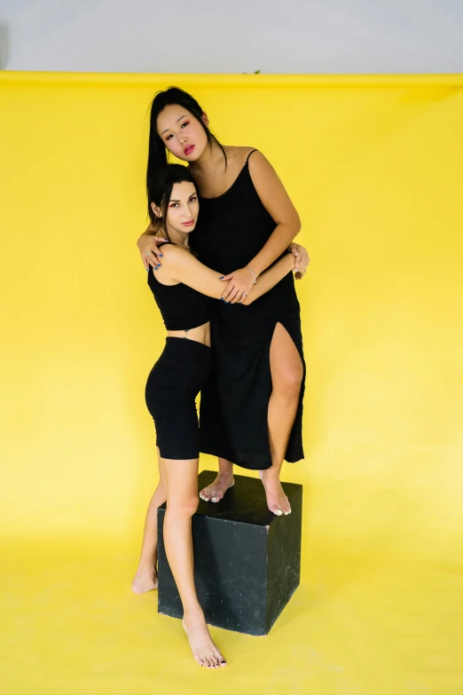 two beautiful woman in black dresses posing for a picture