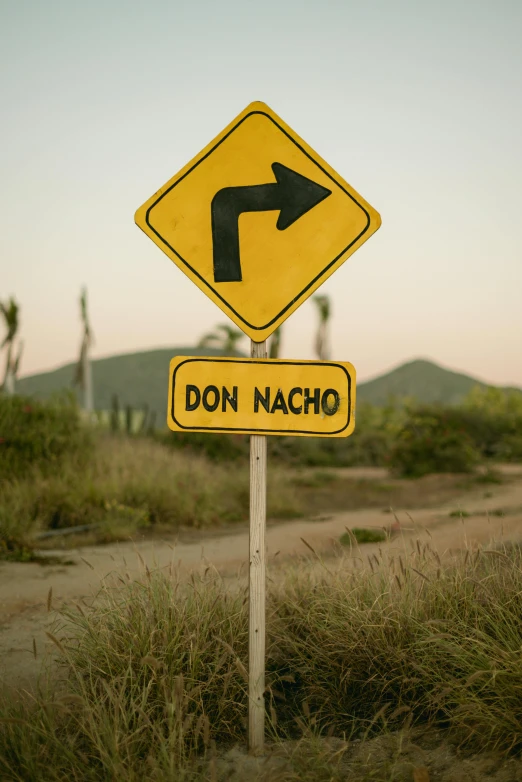 a yellow and black street sign that is on a pole