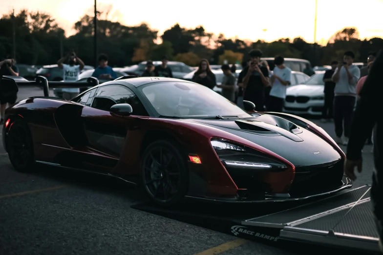 a red and black sports car is parked in a lot