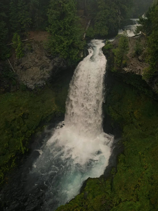 there is a large waterfall that is coming out of the woods