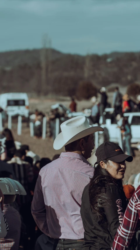 some people with a cowboy hat on some dirt