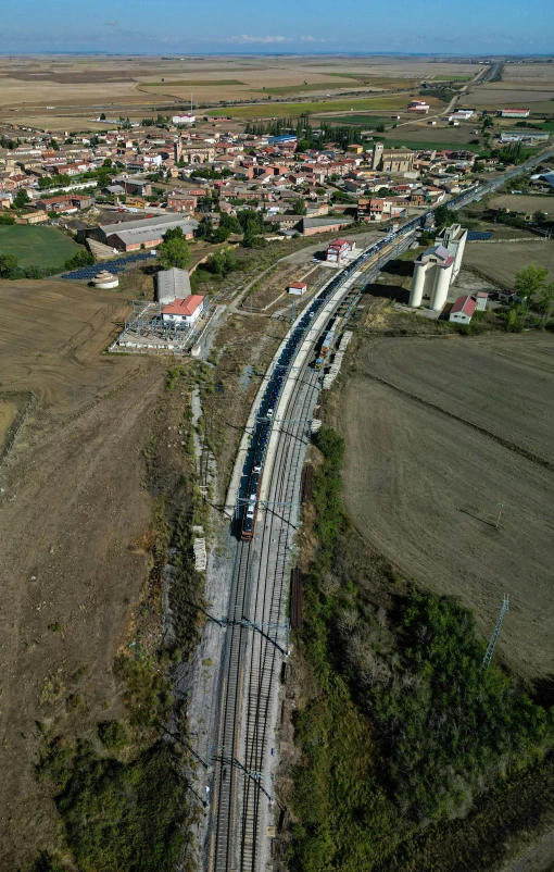 a train on the tracks in front of some buildings and fields