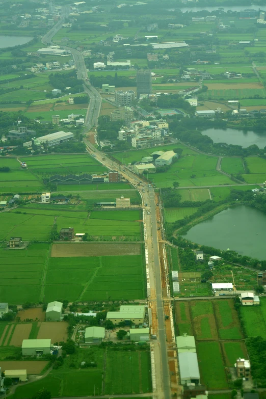 an aerial view of a city, water and fields from above
