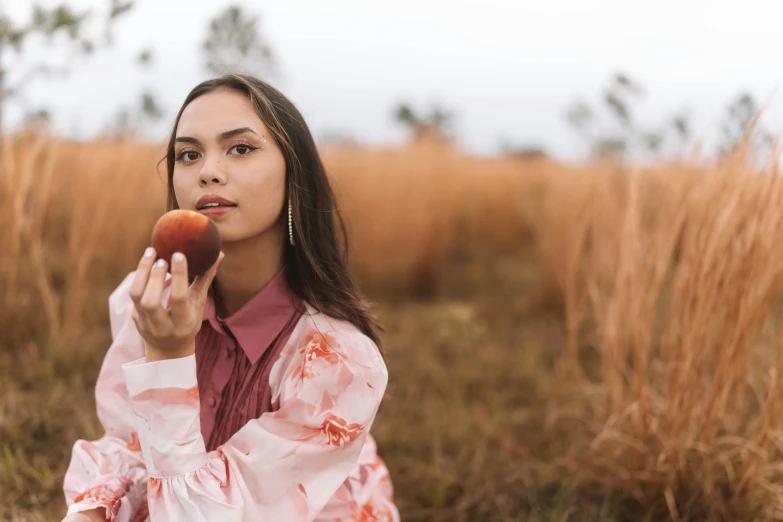 the woman is eating an apple in her hand